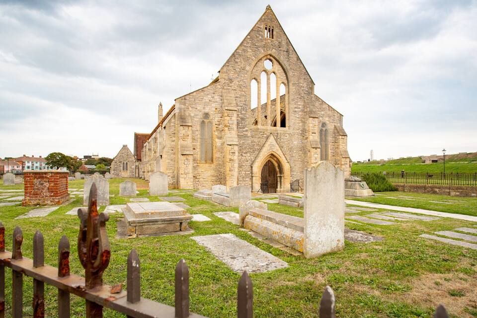 A historic church with a large arched entrance and a tall bell tower.