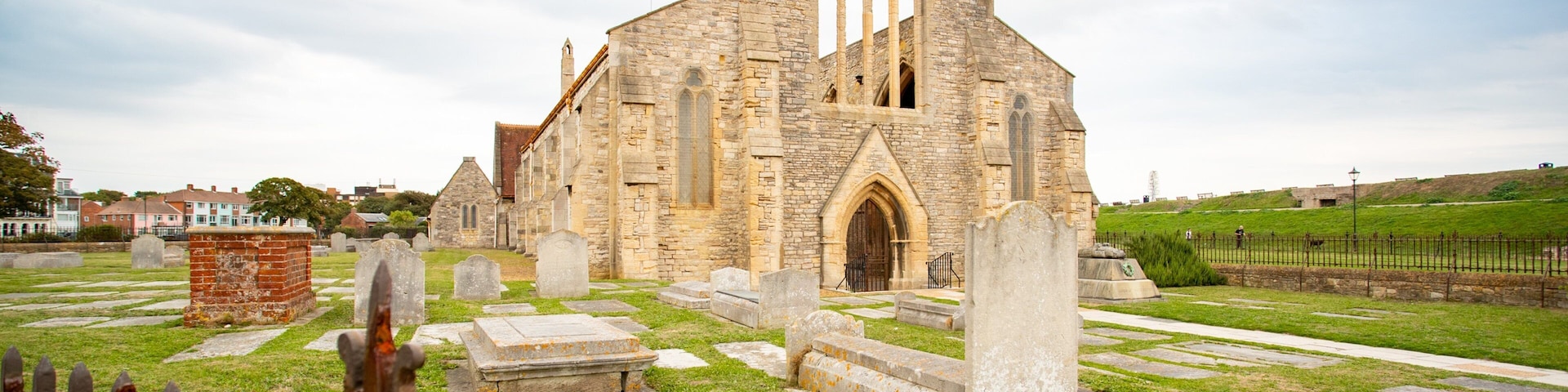 Uma igreja histórica com uma grande entrada em arco e uma alta torre do sino.