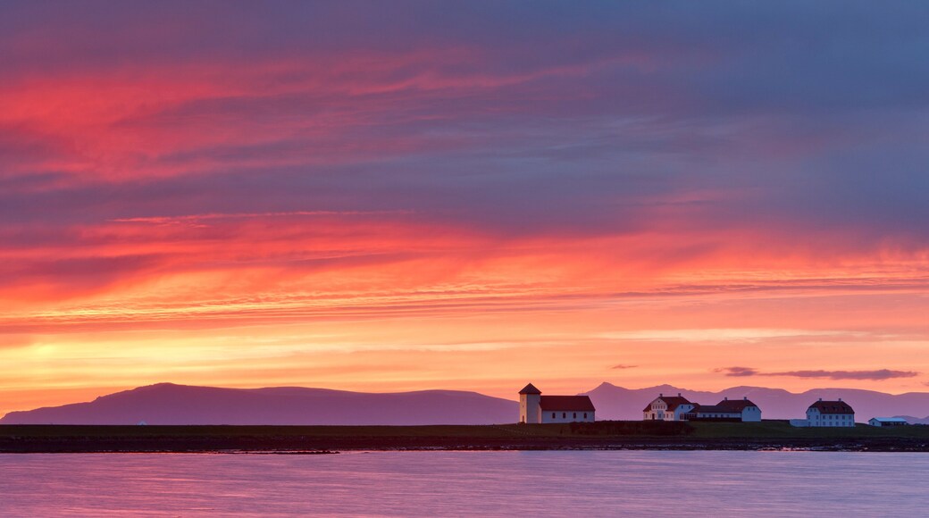 Mountain range and presidents residence building in remote setting at sunset, Bessastadir, Alftanes, Iceland