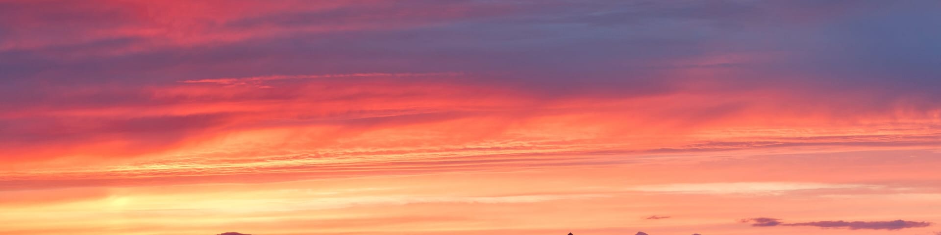 Mountain range and presidents residence building in remote setting at sunset, Bessastadir, Alftanes, Iceland
