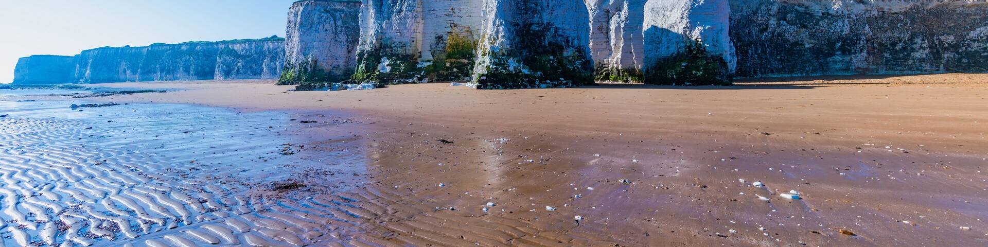View of white chalk stacks, cliffs, sea at low tide and beach in Botany Bay, Margate, East Kent, UK
