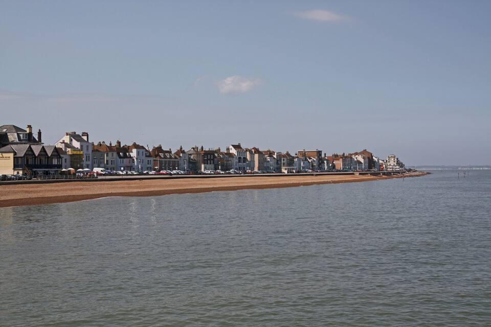 A coastal town with a sandy beach and a row of traditional houses along the water's edge.