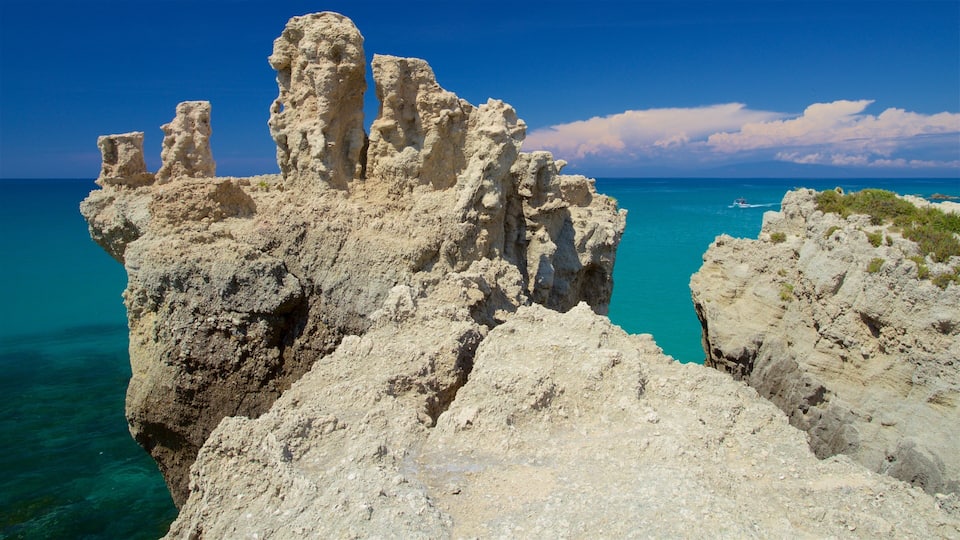 A rugged coastal landscape with prominent rock formations and clear turquoise waters.