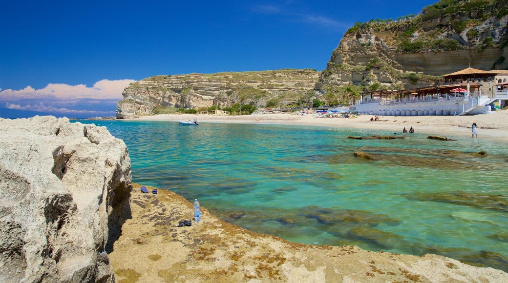 Riaci Beach which includes rocky coastline, general coastal views and tropical scenes