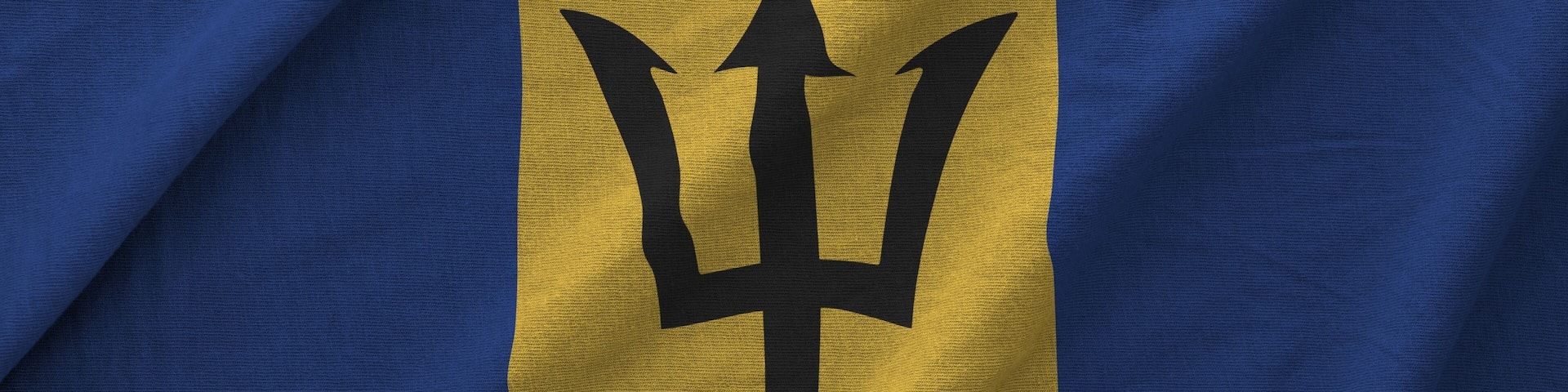 Barbados flag depicted on folded wavy fabric of old cloth close up