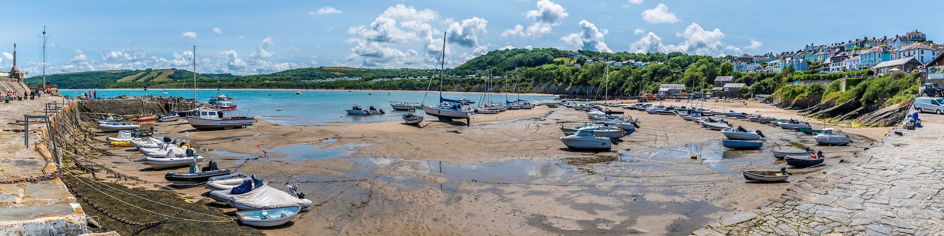 A panorama view from the harbour wall at low tide in the town of New Quay, Wales in summertime