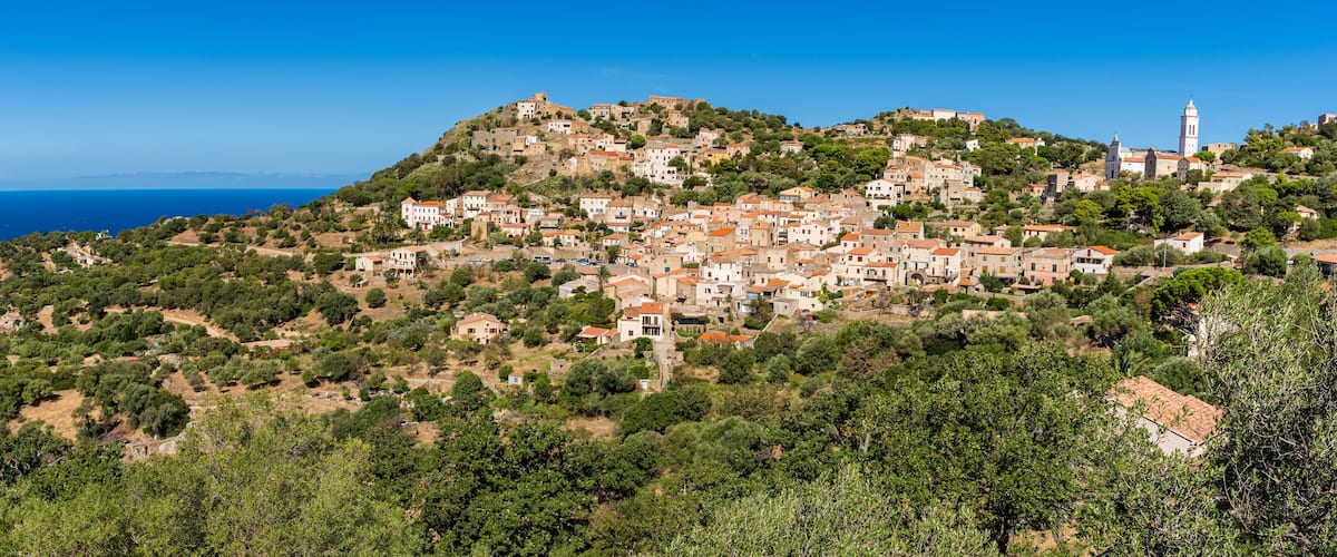 View of Corbara village with stone houses built in traditional Corsican style on top of a hill, Corsica, France