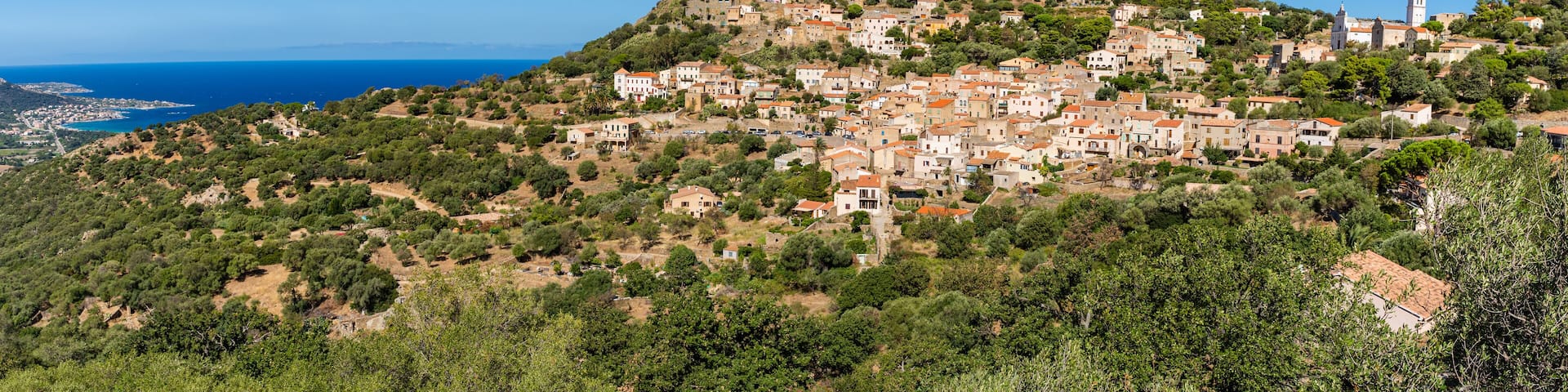 View of Corbara village with stone houses built in traditional Corsican style on top of a hill, Corsica, France