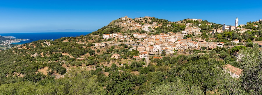 View of Corbara village with stone houses built in traditional Corsican style on top of a hill, Corsica, France