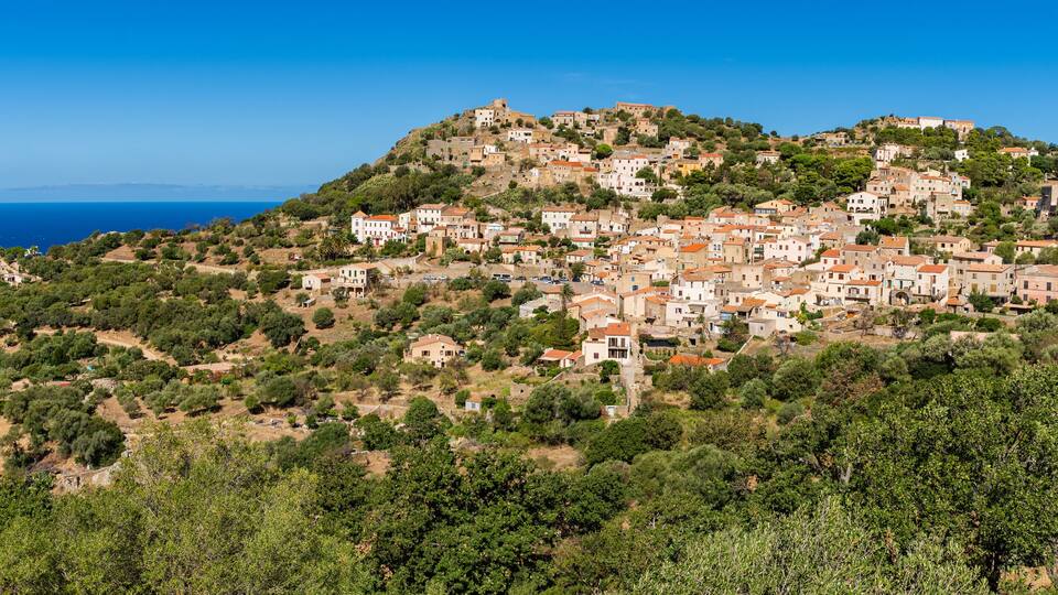 View of Corbara village with stone houses built in traditional Corsican style on top of a hill, Corsica, France