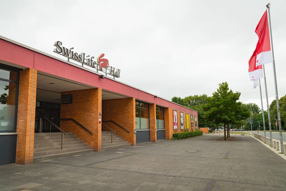 Een gebouw met een rode gevel en het bord 'SwissLife Hall'.