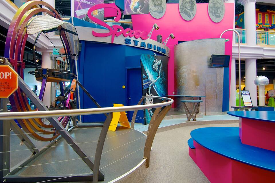 Un espace intérieur coloré, agrémenté d’une enseigne « Space Stadium », d’un panneau « STOP ! » et d’une grande structure métallique.