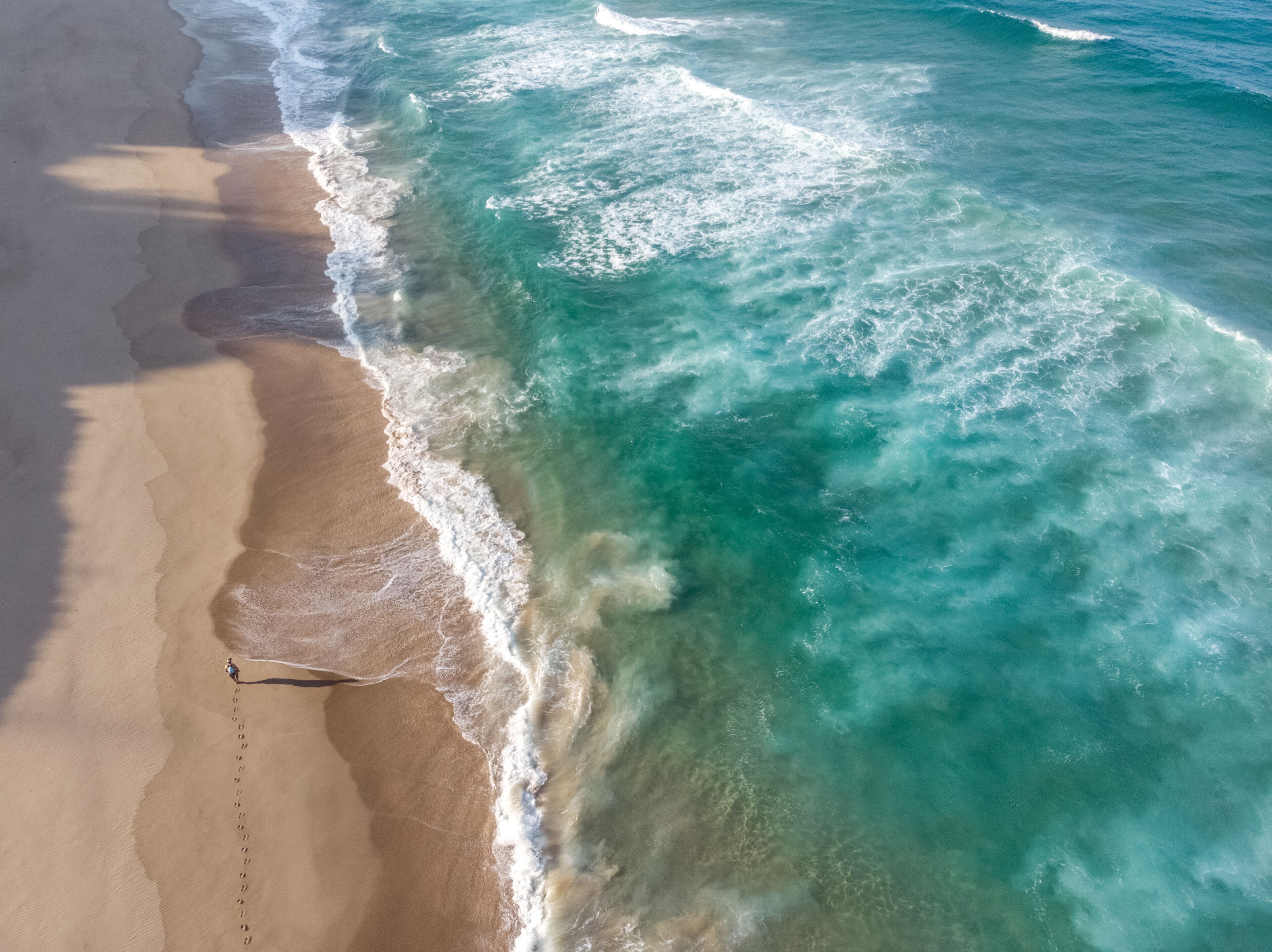 A sandy beach with waves crashing onto the shore.