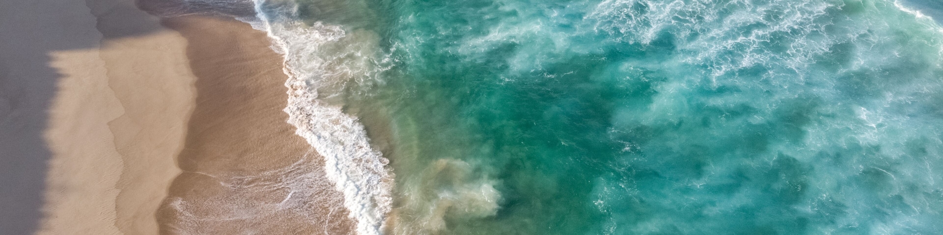 A sandy beach with waves crashing onto the shore.