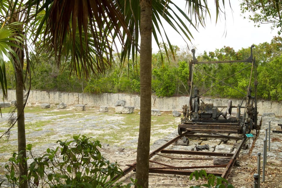 An archaeological site with stone structures and metal machinery.