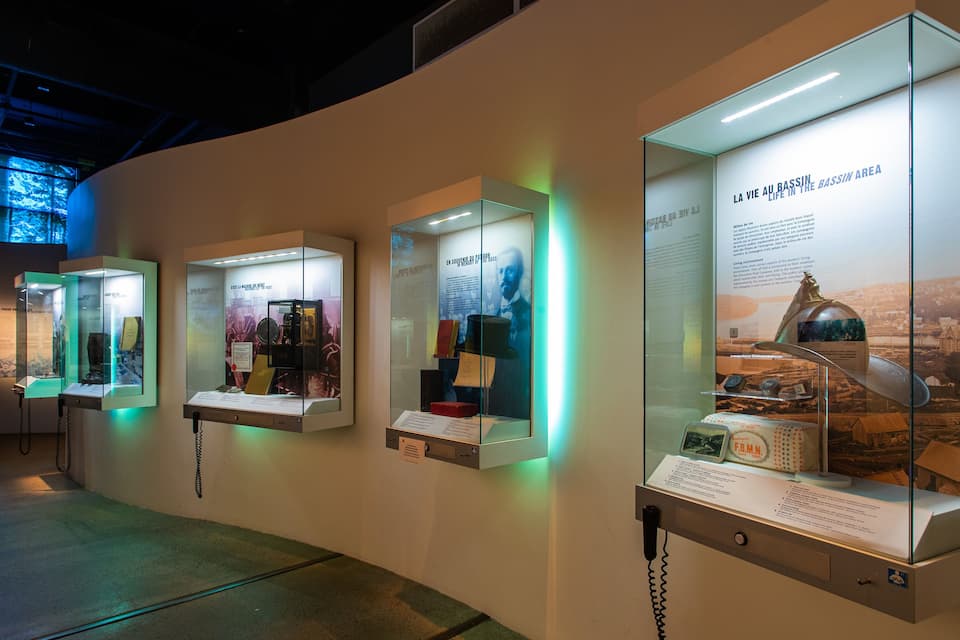 Una exposición de museo con vitrinas de cristal que albergan artefactos históricos y paneles informativos.