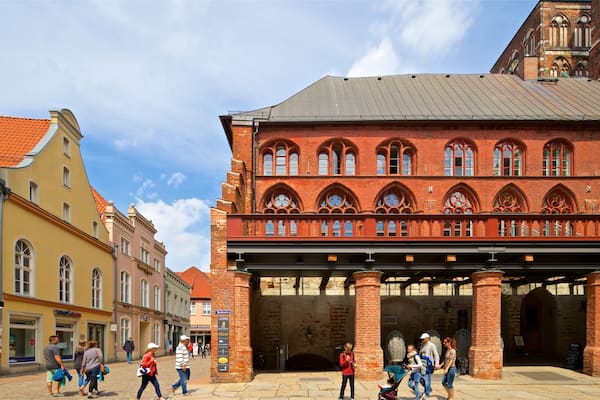 Ein historisches Gebäude mit roten Backsteinbögen und einem überdachten Gang.