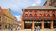 A historic building with red brick arches and a covered walkway.