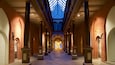 A long corridor with brick walls, large columns, and a skylight.