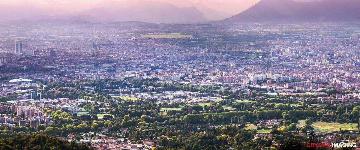 A cityscape with a large park, buildings, and mountains in the background.