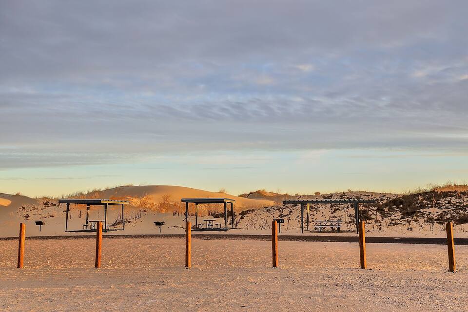 A desert landscape with picnic tables and a clear sky.