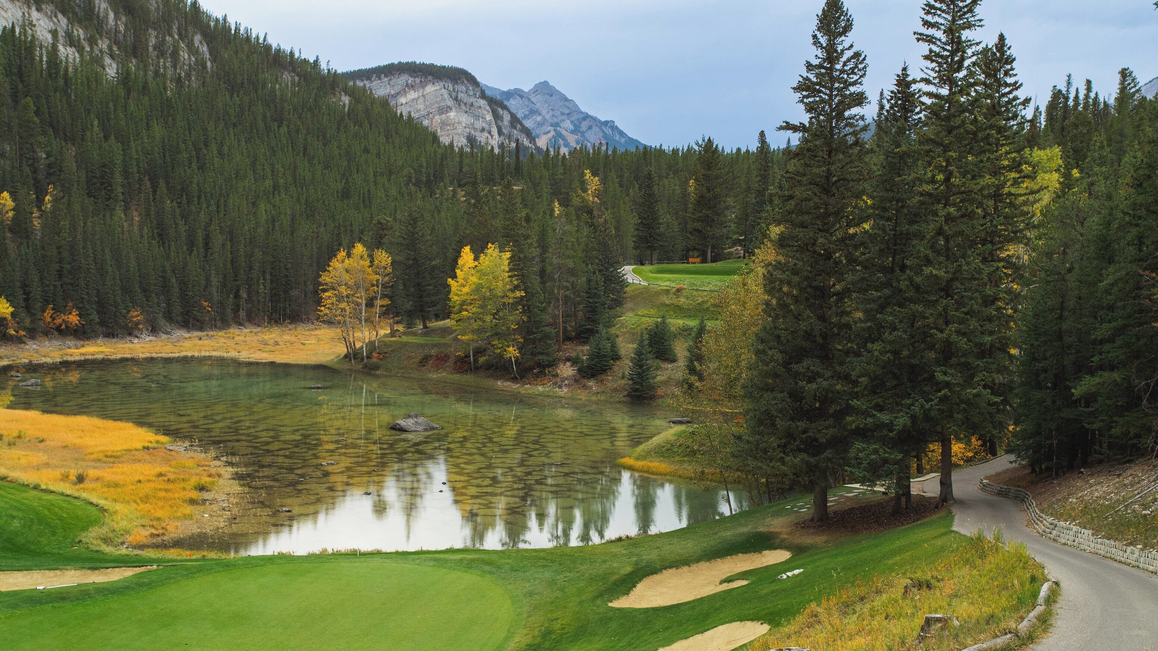 Breathtaking view of Banff Springs Golf Club in Banff, Alberta during autumn with vibrant foliage and tranquil water reflections