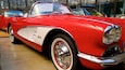 A classic red and white car with chrome details and a visible license plate.