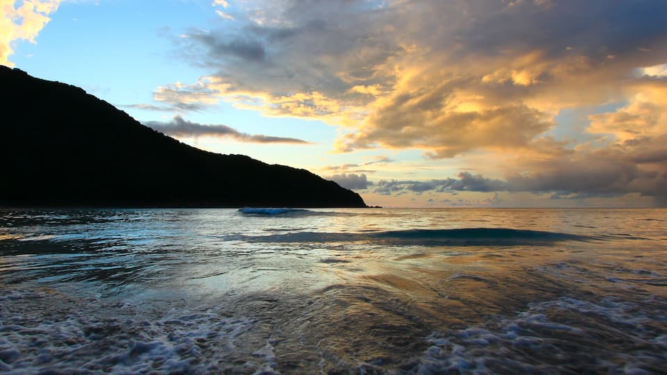 A coastal landscape with a mountain and ocean.