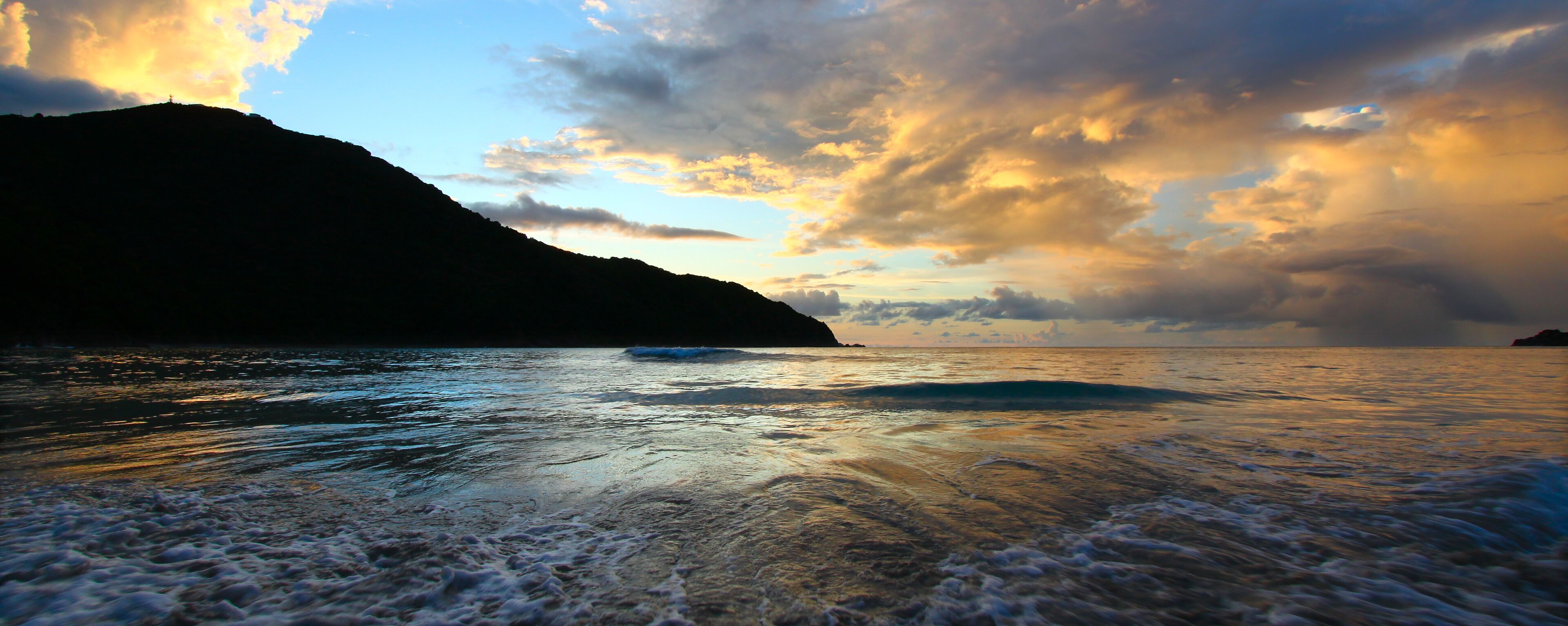 A coastal landscape with a mountain and ocean.