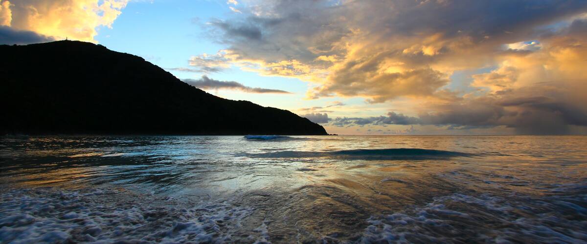 A coastal landscape with a mountain and ocean.