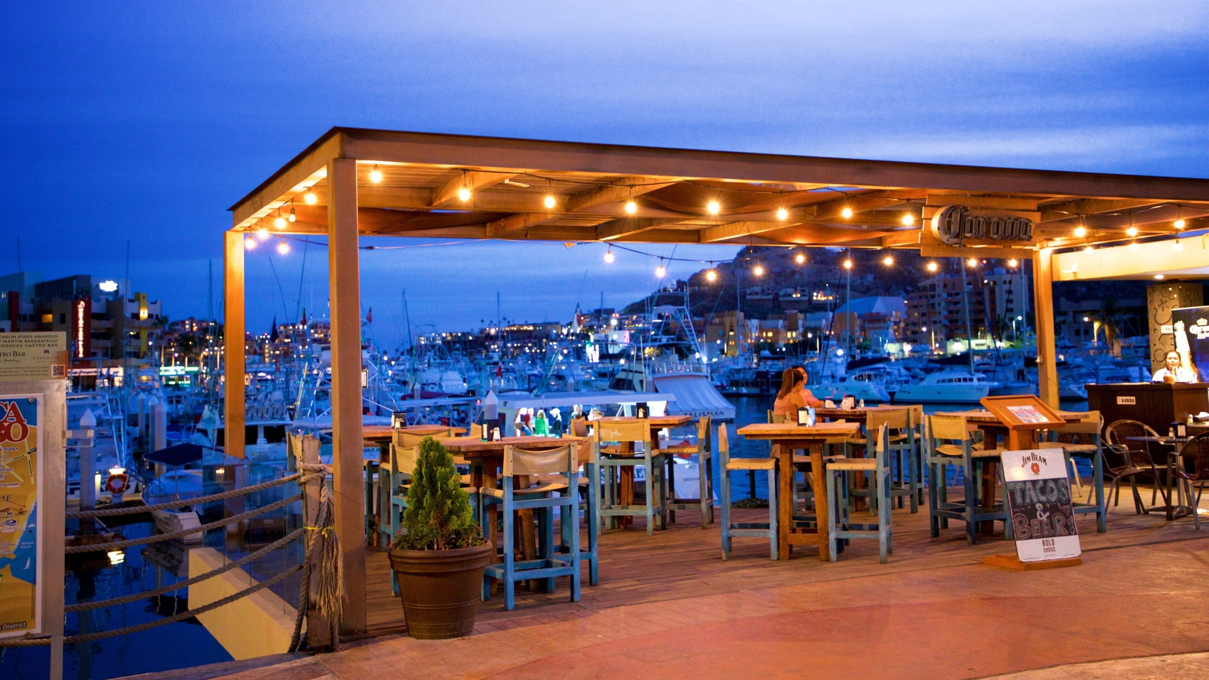 Un restaurant al costat del mar amb terrassa i llums lluminoses.