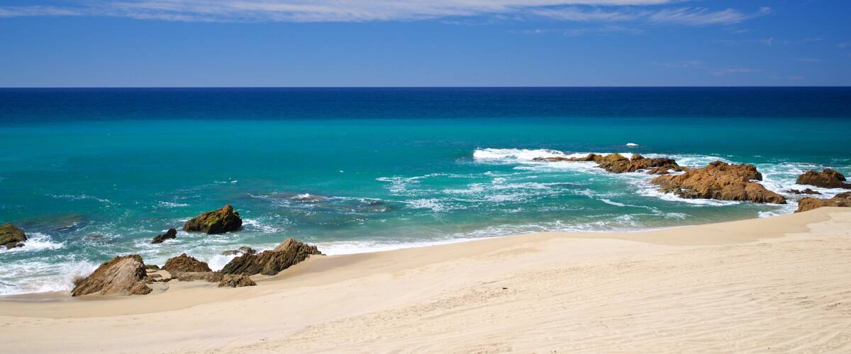 Migrino which includes a sandy beach, rocky coastline and general coastal views