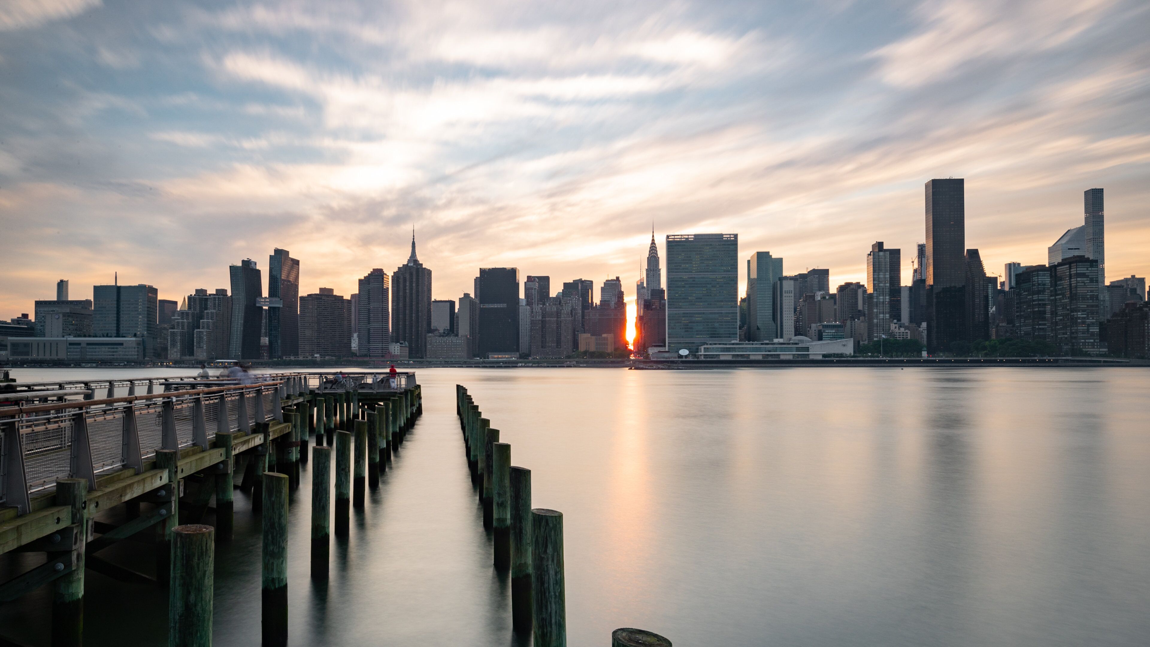 Gantry Plaza State Park which includes a sunset, a city and a bay or harbor
