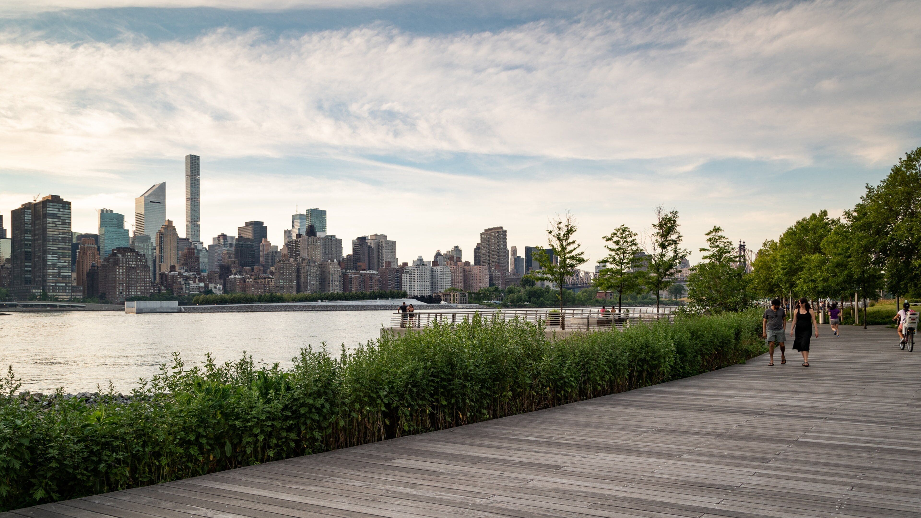 Gantry Plaza State Park which includes a bay or harbor, a city and a sunset