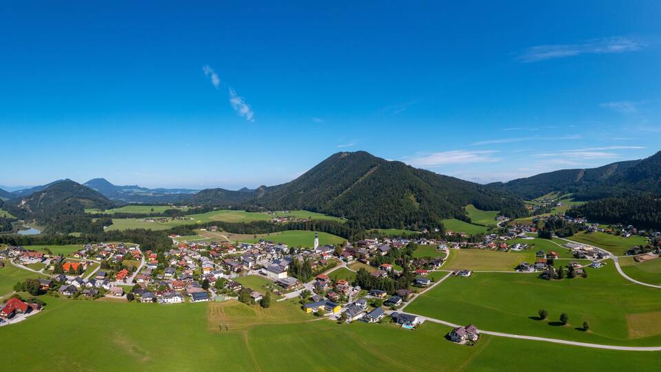 A village nestled in a valley surrounded by mountains.