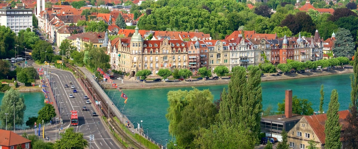 A riverside town with historic buildings, a bridge, and a river.