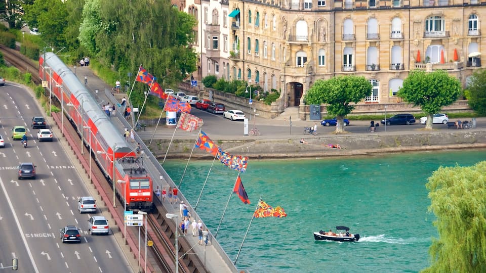A bridge with a red train, a river, and a boat.