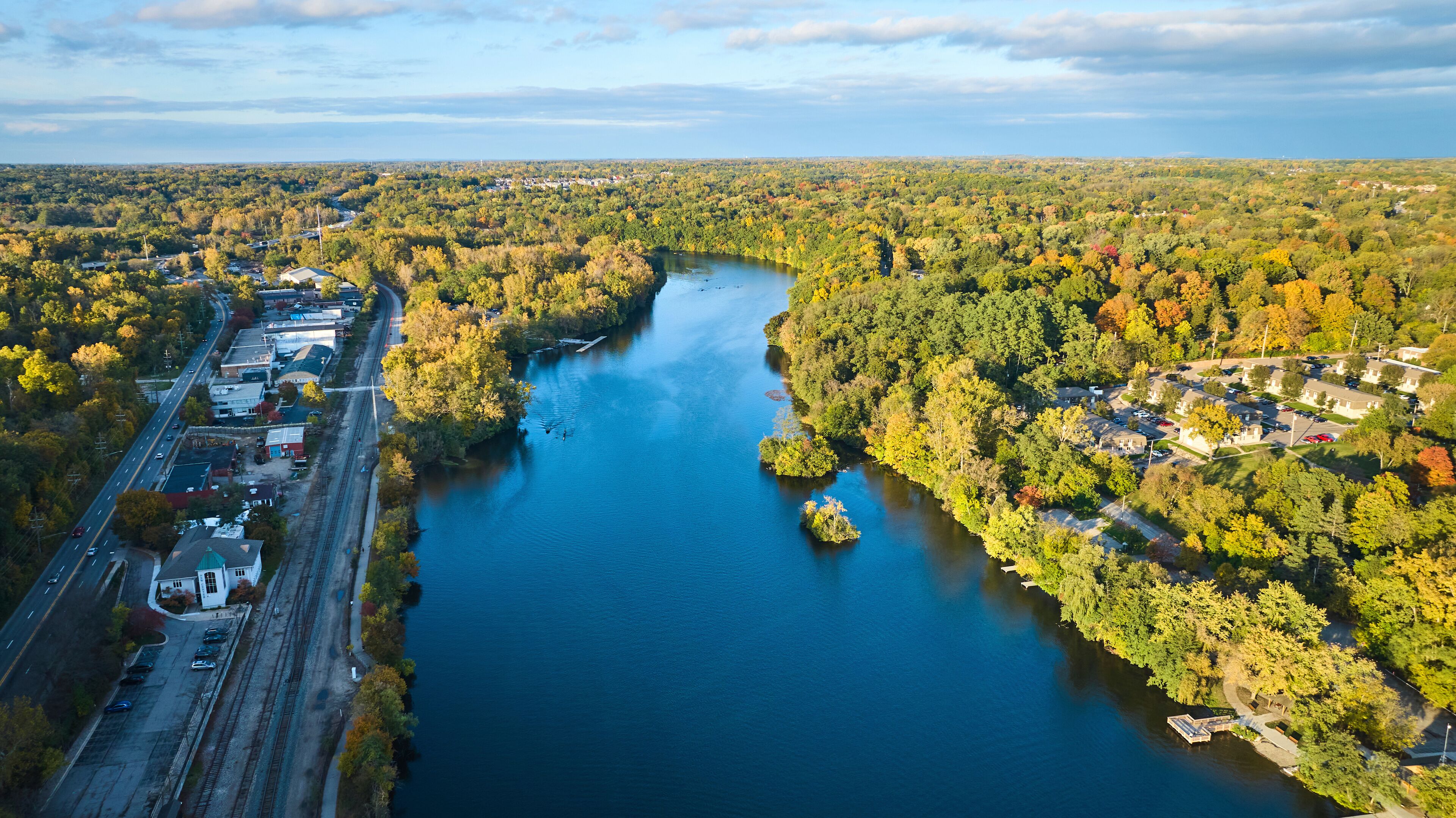 Aerial View of Serene River and Autumnal Trees in Small Town