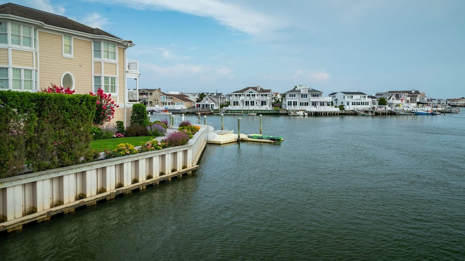 A waterfront with houses, a dock, and boats.