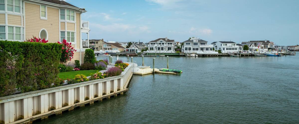 A waterfront with houses, a dock, and boats.