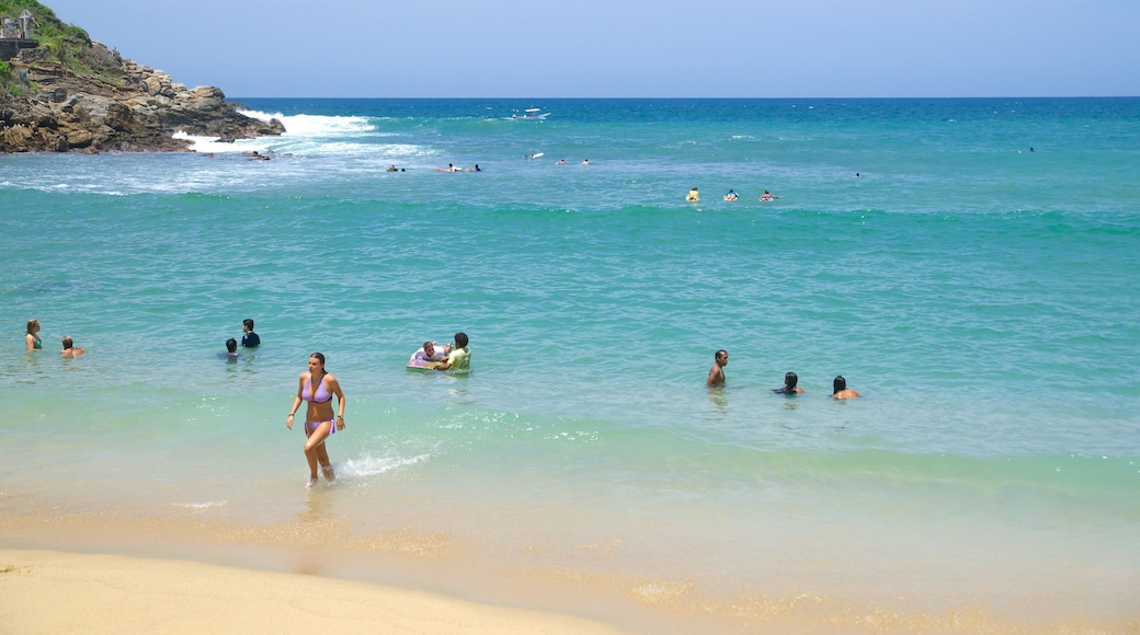 Playa de Carrizalillo ofreciendo una playa y natación y también un gran grupo de personas