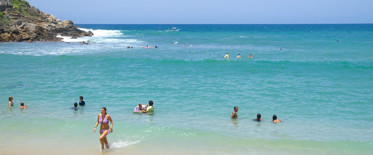 Carrizalillo Beach which includes a beach and swimming as well as a large group of people