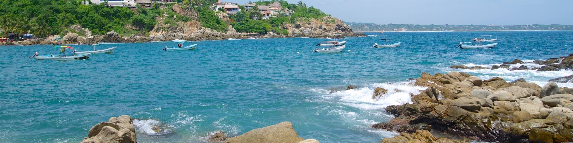 Puerto Angelito-stranden som inkluderar en hamn eller havsbukt och klippig kustlinje