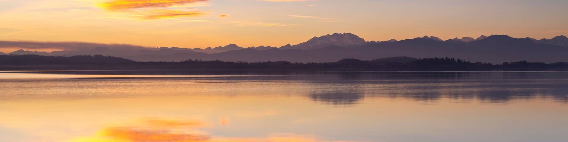 Monte Rosa reflecting on Lake Varese during a winter sunset at Calcinate del Pesce, Varese Province, Lombardy, Italy.