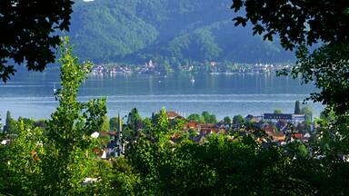 A lake surrounded by a town and forested hills.