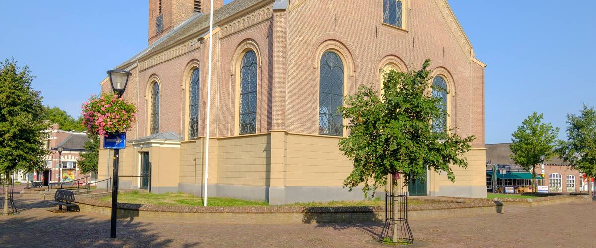 A brick church with a tower and arched windows.
