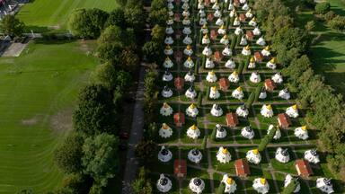 Slagharen, Netherlands - 03 October 2023: Aerial view of the Wigwam Parc's distinctive wigwam-shaped accommodations, a vibrant tapestry of red roofs and white walls amidst lush greenery.
