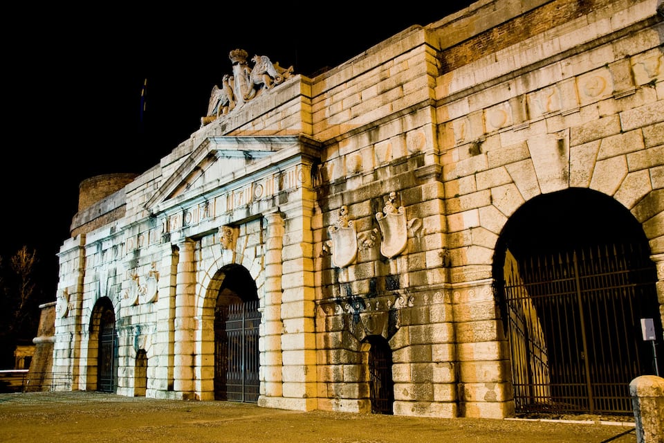 Um edifício histórico de pedra com portas em arco e esculturas decorativas.