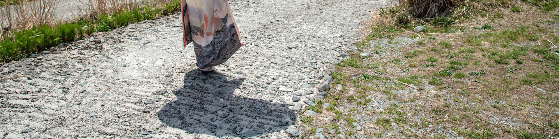 Woman in traditional Japanese dress walking down a winding road in Japan's Iya Valley on the island of Shikoku; Miyoshi City, Shikoku, Japan