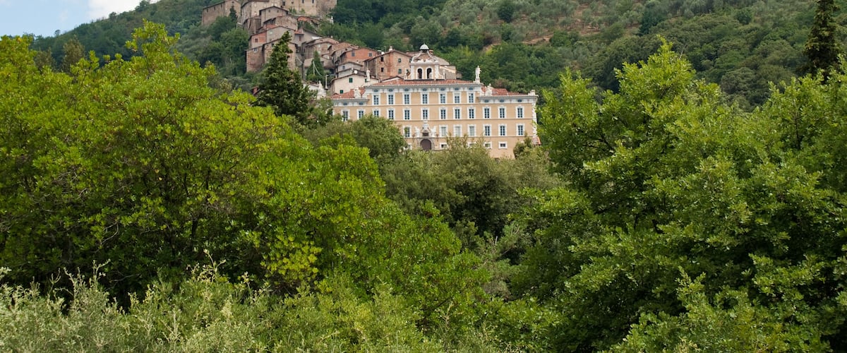 A historic building on a hill with lush greenery and a clear sky.